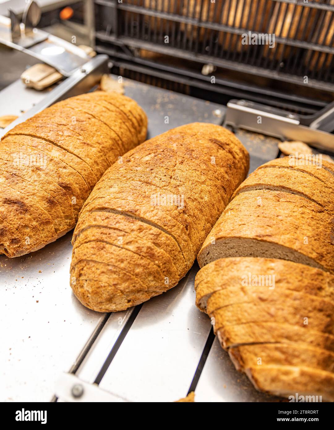 https://c8.alamy.com/comp/2T8RDRT/sourdough-bread-slicing-in-industrial-bread-slicing-machine-in-bread-factory-2T8RDRT.jpg