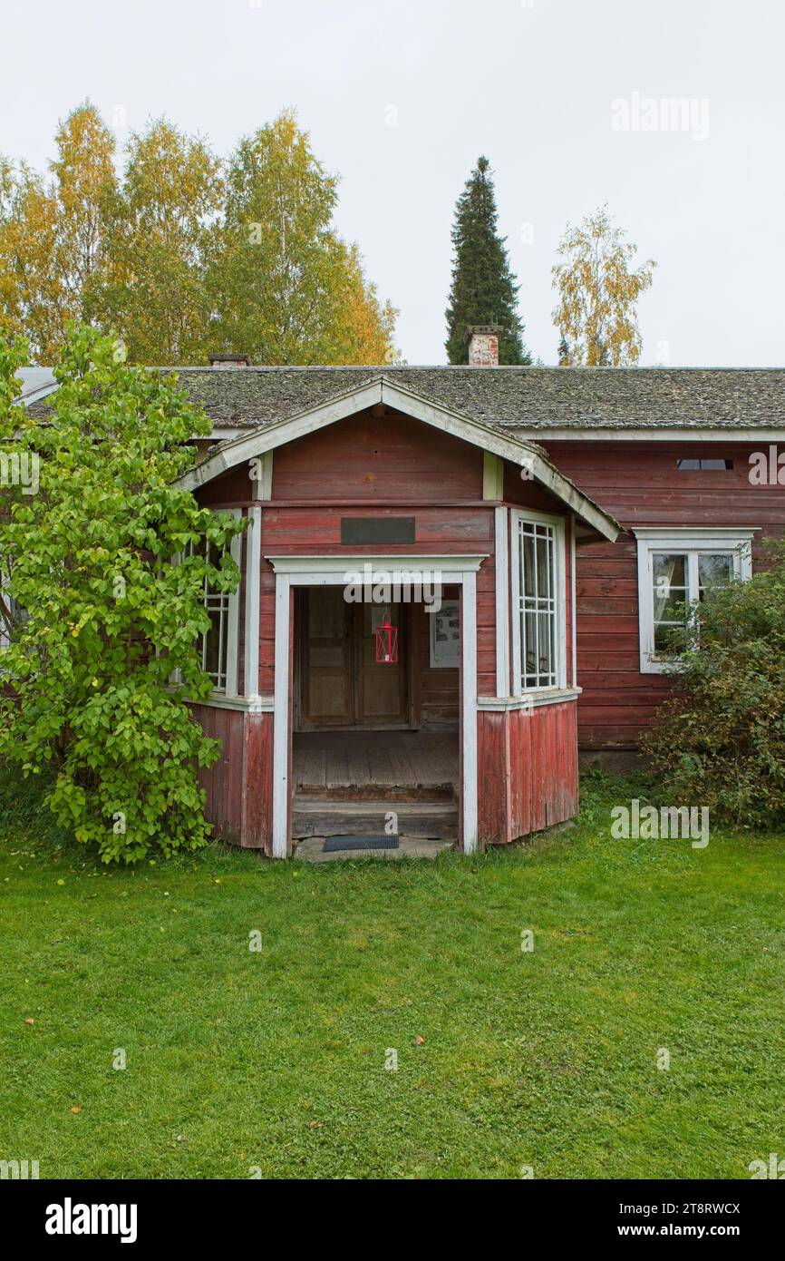 Old weathered traditional painted red wooden building in cloudy autumn weather. Stock Photo