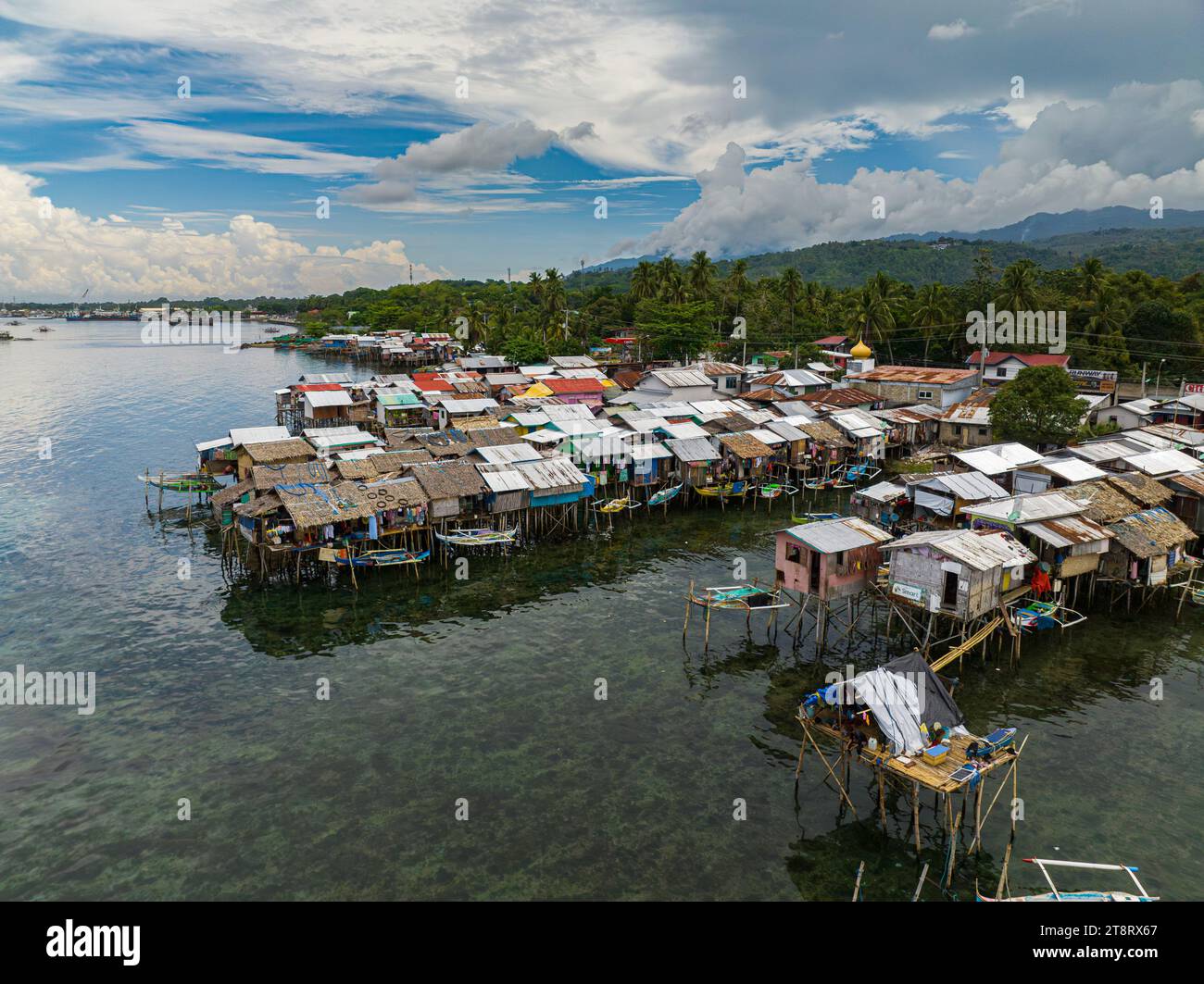 Boats beside stilt houses in Zamboanga raised on stilts. Clear sea water with turquoise water. Mindanao, Philippines. Stock Photo