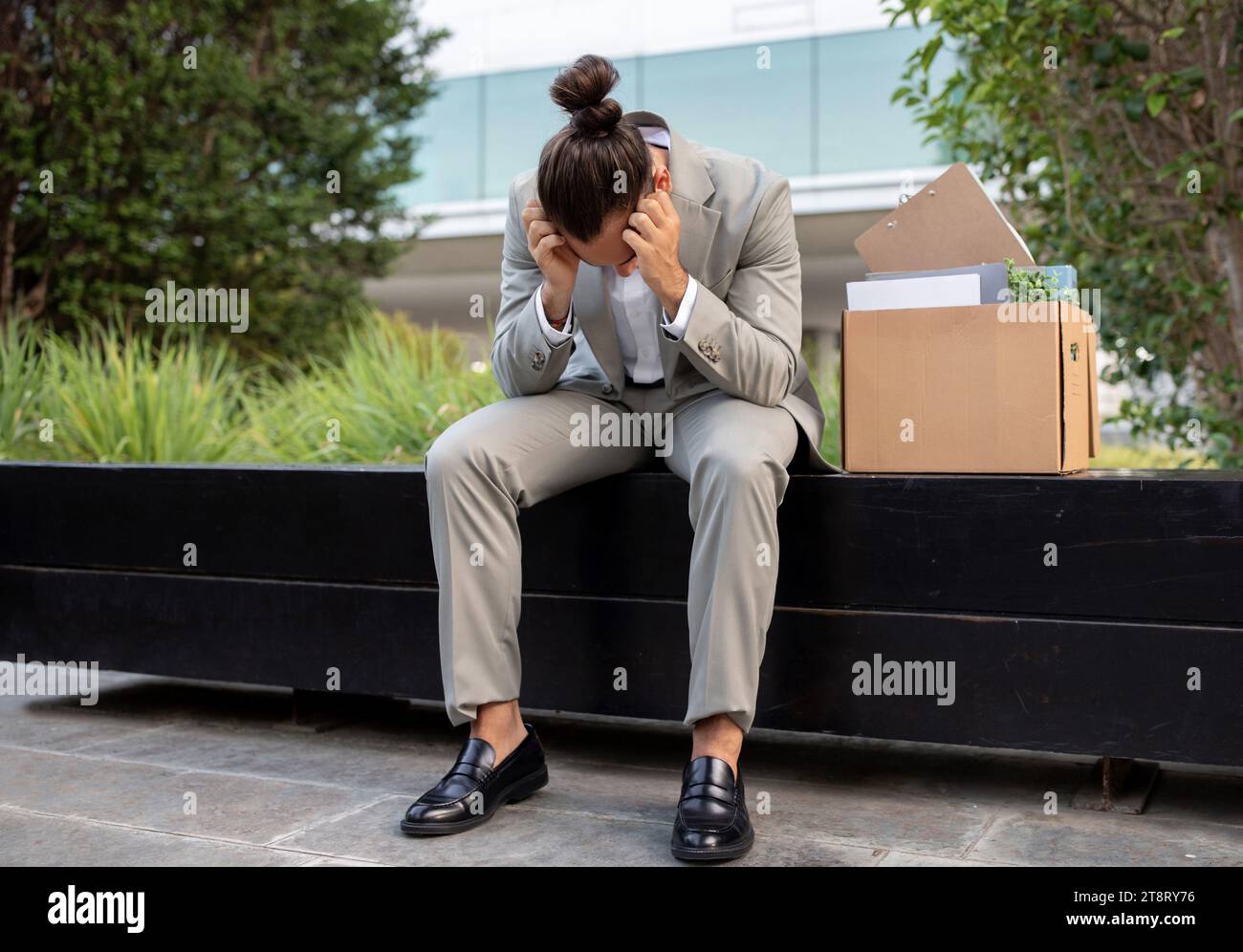 Unemployment Concept. Fired Depressed Male Employee In Suit Sitting On Bench Outdoors, Stock Photo