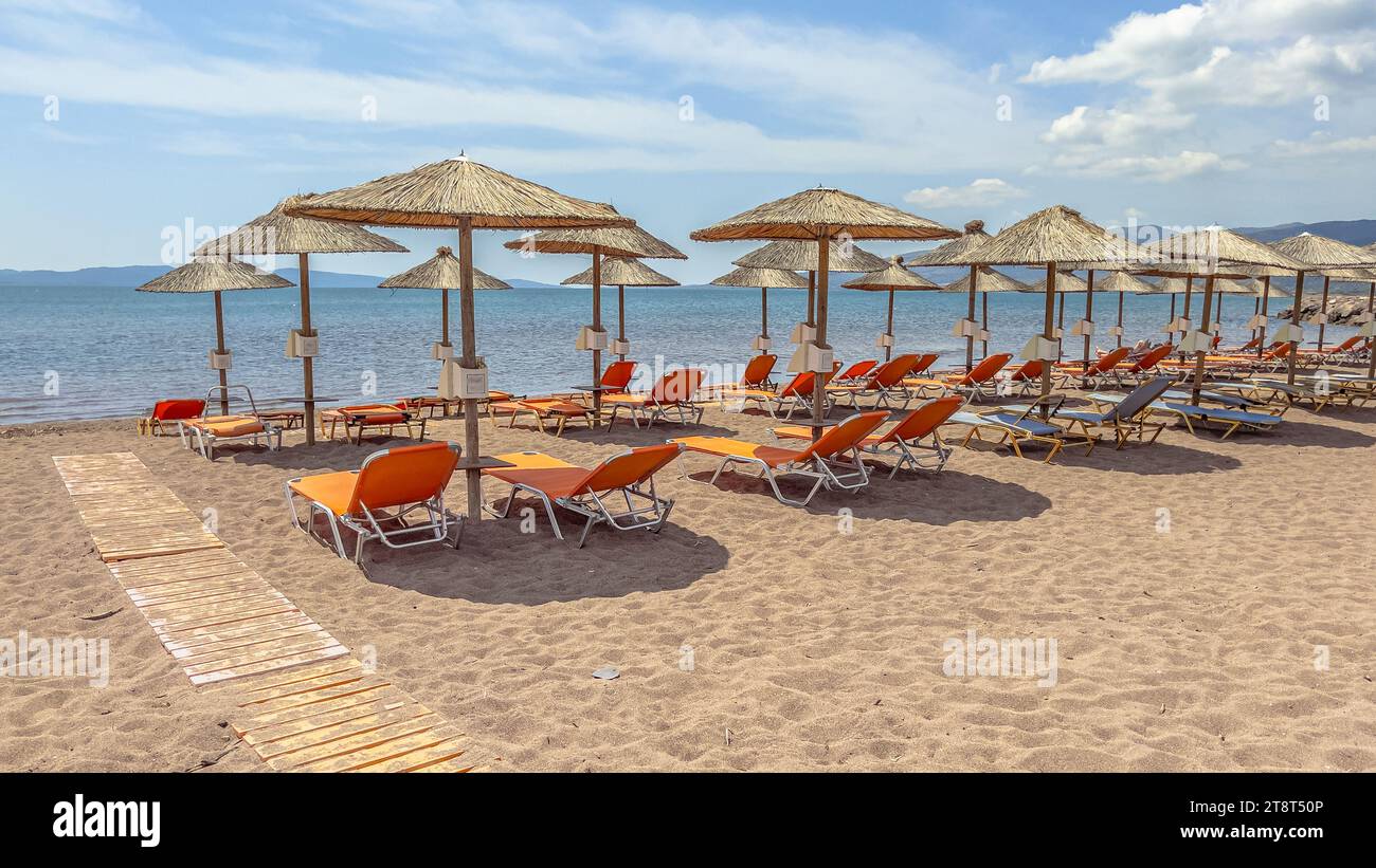 Thatched parasols on a beach on Lesbos island in Greece. Idyllic scene of Greek island beach. Europe Stock Photo