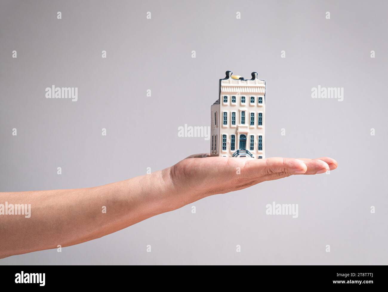 Hand holding a model mansion house. Real estate or property concept. Stock Photo