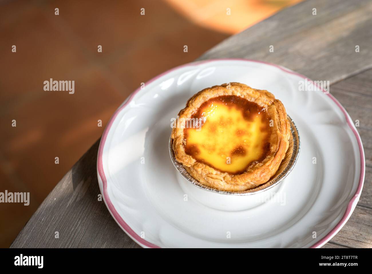 Portuguese egg tart on a white plate. Delicious pastry. Stock Photo