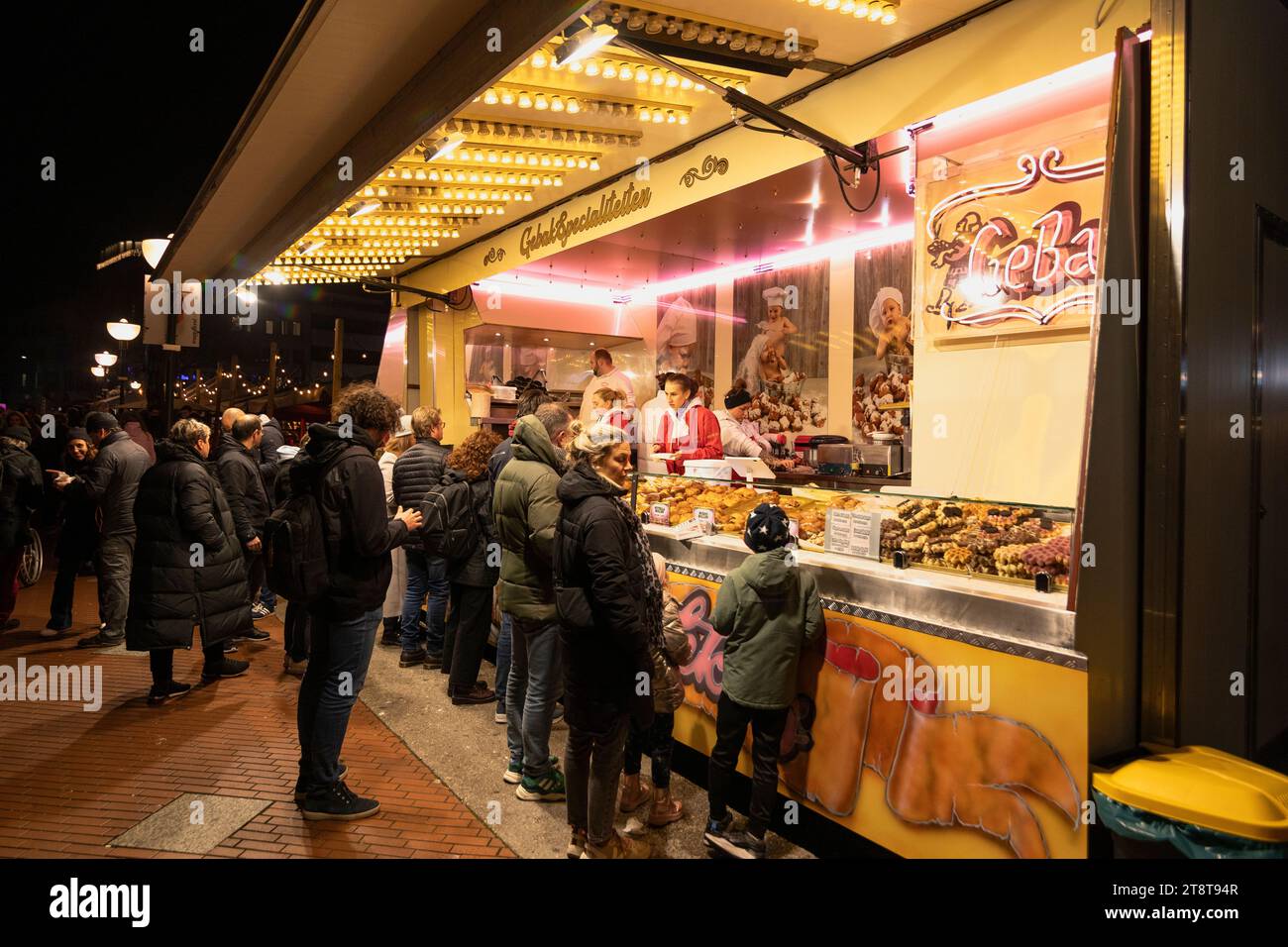 People at pastry stall in the inner city of Eindhoven in winter in the evening Stock Photo