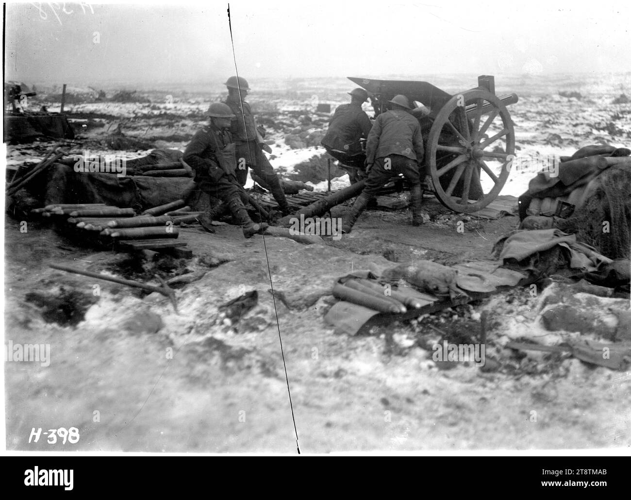 New Zealand artillery in action on the Butte, Belgium, New Zealand artillerymen firing a gun in snowy conditions on the Butte, Belgium, during World War I. View from behind the gun showing uncovered shells. Two soldiers are firing the gun and two soldiers are behind it. Photograph taken 1 January 1918 Stock Photo