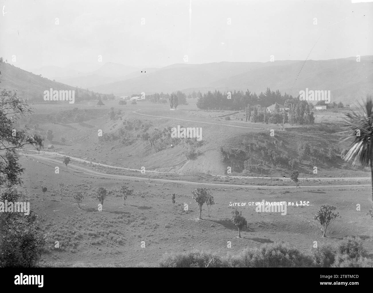 General view of the rural landscape near the settlement of Otoko showing the site of the viaduct, View of the settlement of Otoko, showing the rural landscape. There is a a road in the middle foreground running from left to right. Several farm houses and buildings are visible. Photographed between 1910-1930 Stock Photo