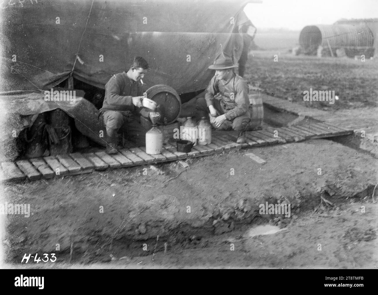 Issuing the rum ration to troops in the front trenches, World War I, Soldiers pouring rum from a barrel into ceramic flagons for issue to troops in the front trenches during World War I. Photograph taken Dickebusch 2 February 1918 Stock Photo