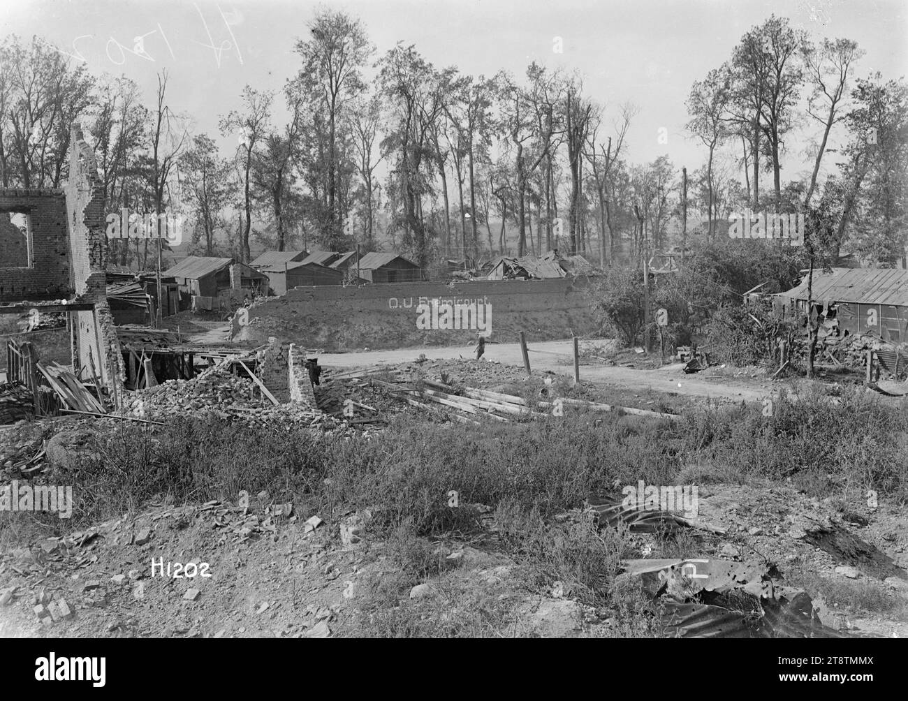 New Zealand Divisional Headquarters at Fremicourt, France, World War I, A general view over the New Zealand Divisional Headquarters at Fremicourt, France during World War I. Probably the front entrance. Shows huts and tents behind a wall on which is written in large letters 'D U? Fremicourt'. Also shows earlier war damage to buildings and surrounds. Photograph taken 7 September 1918 Stock Photo