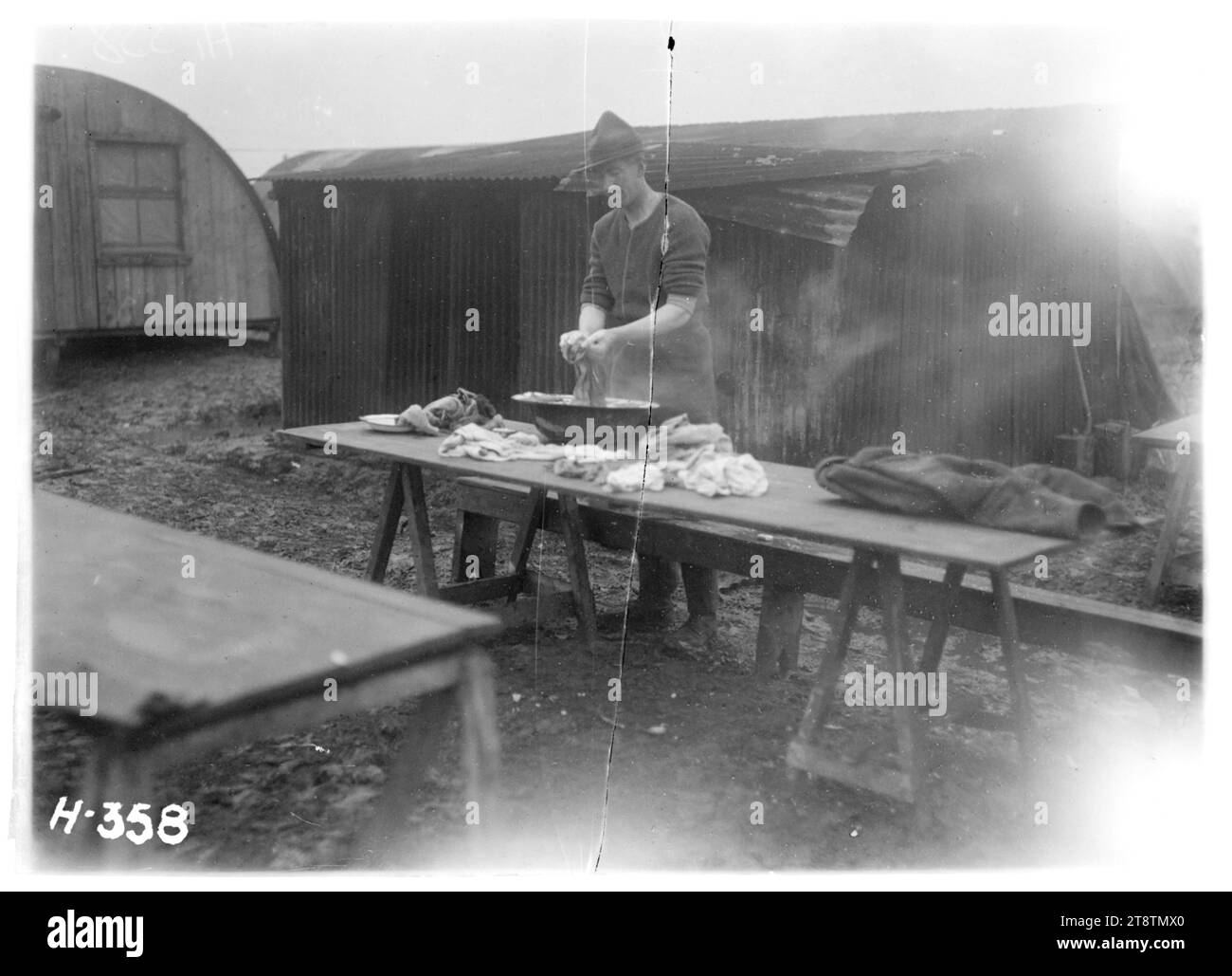 A New Zealand soldier doing his washing at Chateau Segard, World War I, A World War I New Zealand soldier standing at a wooden table washing his clothes in a large bowl. Photograph taken at Chateau Segard, near Dickebusch in late 1917 Stock Photo