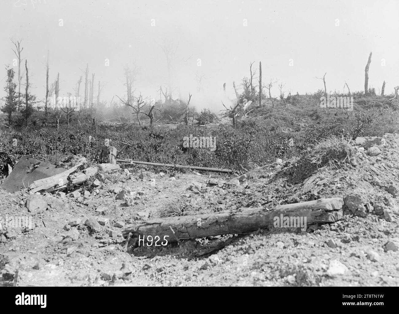 A German dugout burning in World War I, Puisieux, France, A German dugout in a bank burns after the retreating Germans fired the ammunition in it. Shows smoke over mounds of earth and pieces of wood and iron. The trees in the background have been stripped by shelling. Photograph taken Puisieux 21 August 1918 Stock Photo