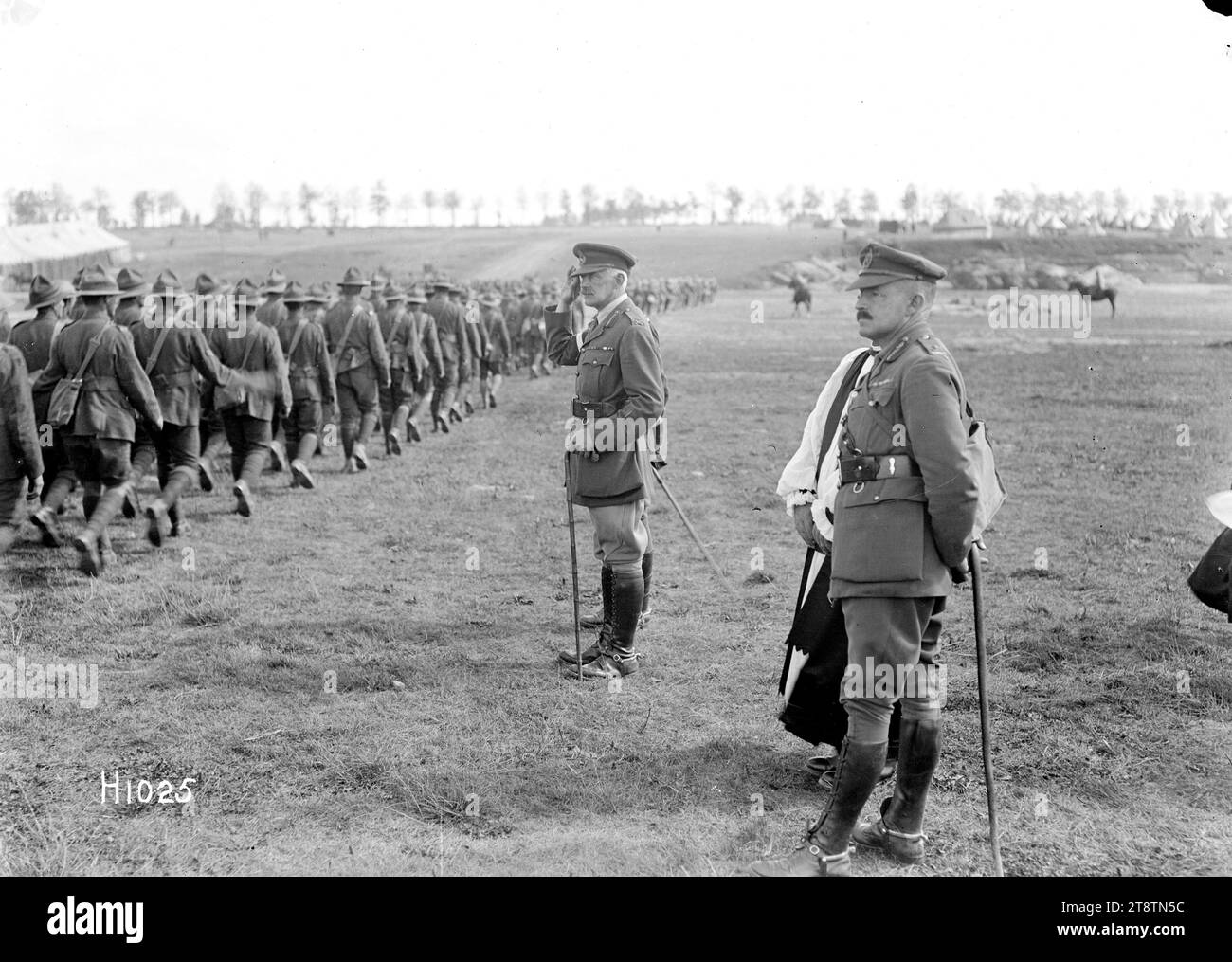 The Corps Commander takes the salute after a New Zealand Brigade church service in World War I, The Corps Commander taking the salute after a New Zealand Brigade church service in France during World War I. The Divisional Commander, Major General Russell stands in the right foreground. The troops file past down a slight slope. Photograph taken Sapignies 8 September 1918 Stock Photo