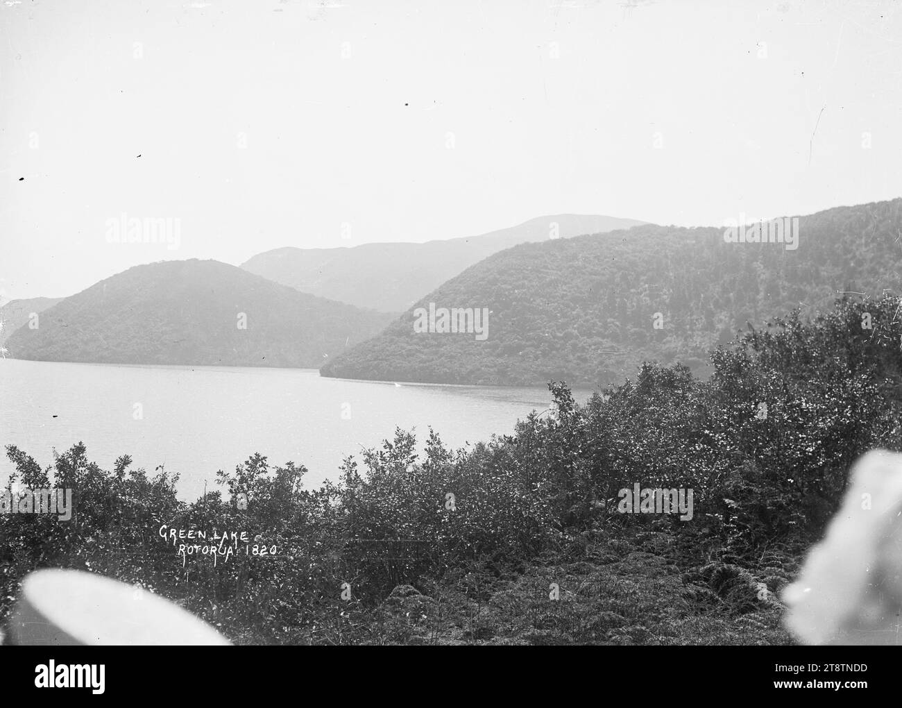Green Lake, Rotorua, View of Lake Rotokakahi, known as the Green Lake, taken from a vantage point on a hill above the lake. in early 1900s Stock Photo