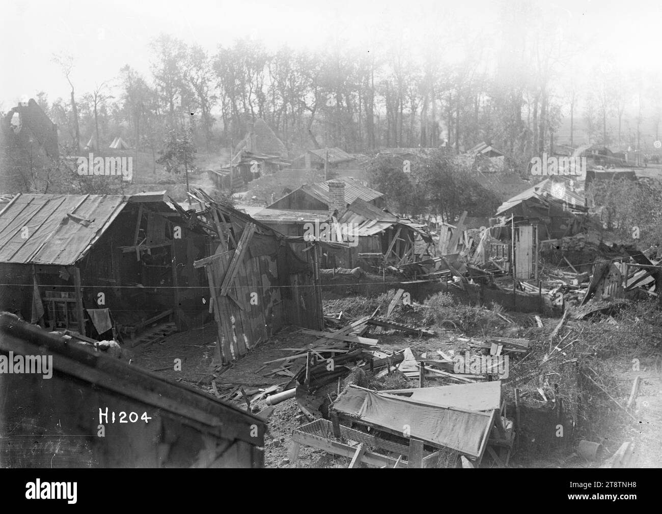 New Zealand Divisional Headquarters at Fremicourt, France, World War I, A general view over the New Zealand Divisional Headquarters at Fremicourt, France during World War I. Shows a number of houses, ramshackle huts and tents with trees in the background. There are many planks of timber and sheets of iron laying on the ground suggesting earlier shell damage, 7 September 1918 Stock Photo