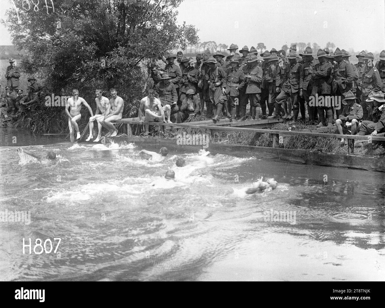 A close finish at the New Zealand Division water sports, World War I, A close finish of a swimming race at the New Zealand Division water sports in France during World War I. The swimmers are watched by soldiers on a bank above. Photograph taken 7 July 1917 Stock Photo