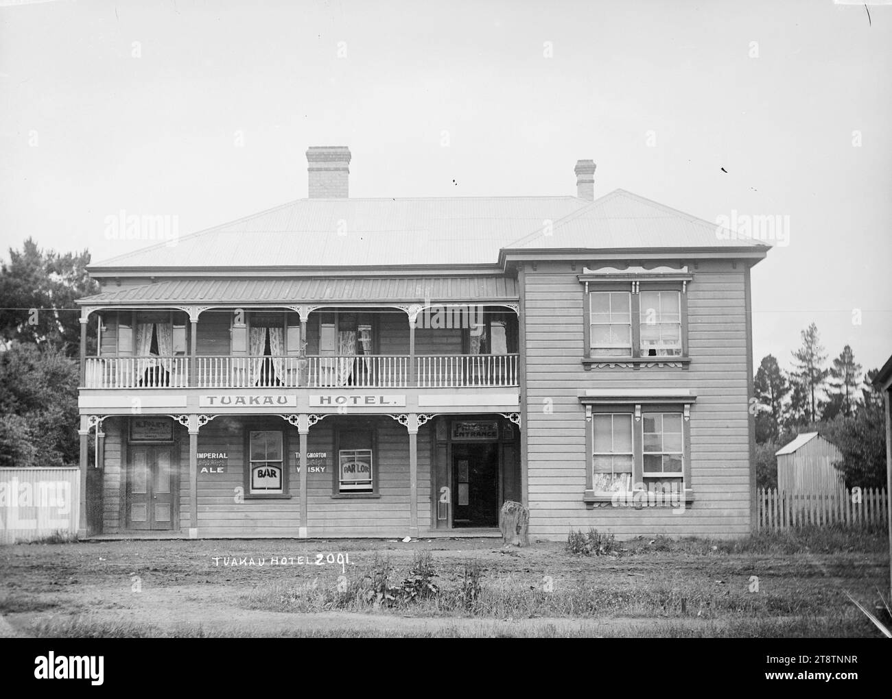 Tuakau Hotel, View of the front facade of the hotel, a two-storeyed wooden building with french doors opening onto the 2nd storey verandah. in early 1900s Stock Photo