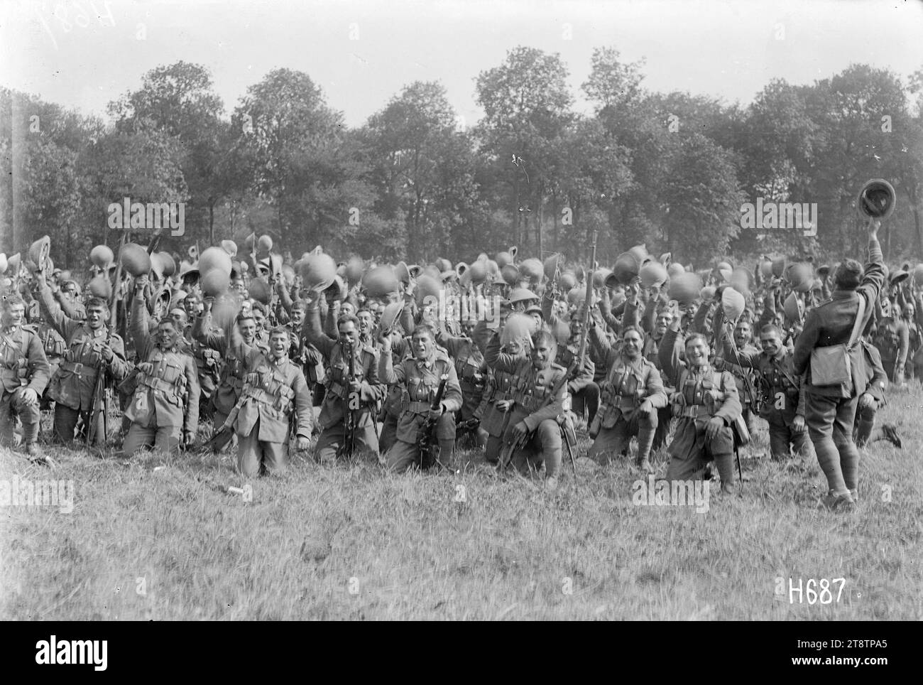 The Pioneer Battalion cheering Massey and Ward on their departure, Bois-de-Warnimont, France, Members of the New Zealand Pioneer Battalion give a rousing farewell to visiting Prime Minister William Massey and Deputy PM Sir Joseph Ward departing after reviewing these troops during World War I. Most soldiers are kneeling on the ground and waving their helmets in the air. Photograph taken at Bois-de-Warnimont, France, 30 June 1918 Stock Photo