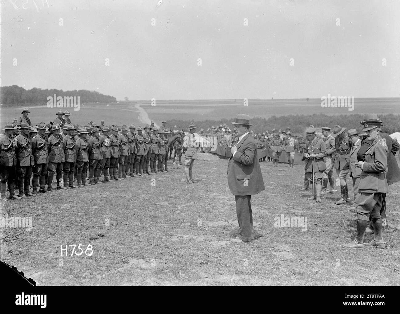 Sir Joseph Ward addressing New Zealand artillery troops in the field during World War I, Louvencourt, A general view of Sir Joseph Ward addressing New Zealand artillery troops in the field at Louvencourt, France, during World War I. Ward stands in the centre foreground. In the official party behind him but obscured is Prime Minister Massey. Clear view of the French countryside in the background. Photograph taken 2 July 1918 Stock Photo