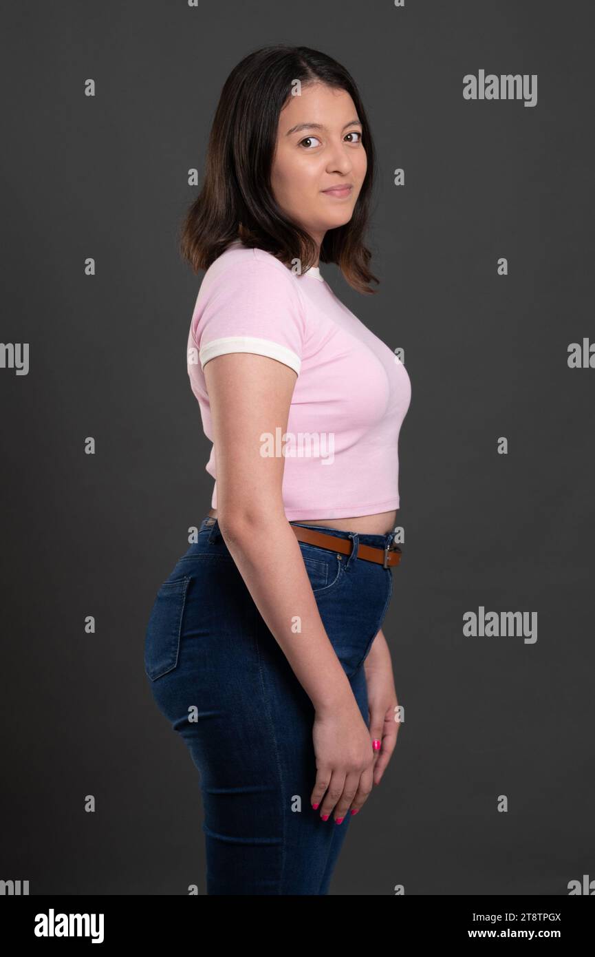 Body positive hispanic woman model side view on gray studio background Stock Photo