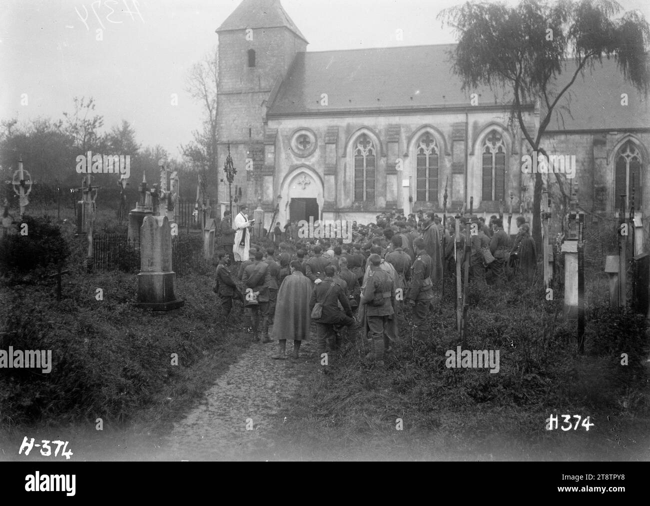 All Souls Day memorial funeral burial service, in the churchyard of St Martin's, Selles, Pas de Calais, France, All Souls Day memorial funeral burial service to commemorate the New Zealand fallen, in the churchyard of St Martin's, Selles, Pas de Calais, France. Shows service being conducted with soldiers standing in front of priests. The church is in the background. Photograph taken 5 November 1917 Stock Photo