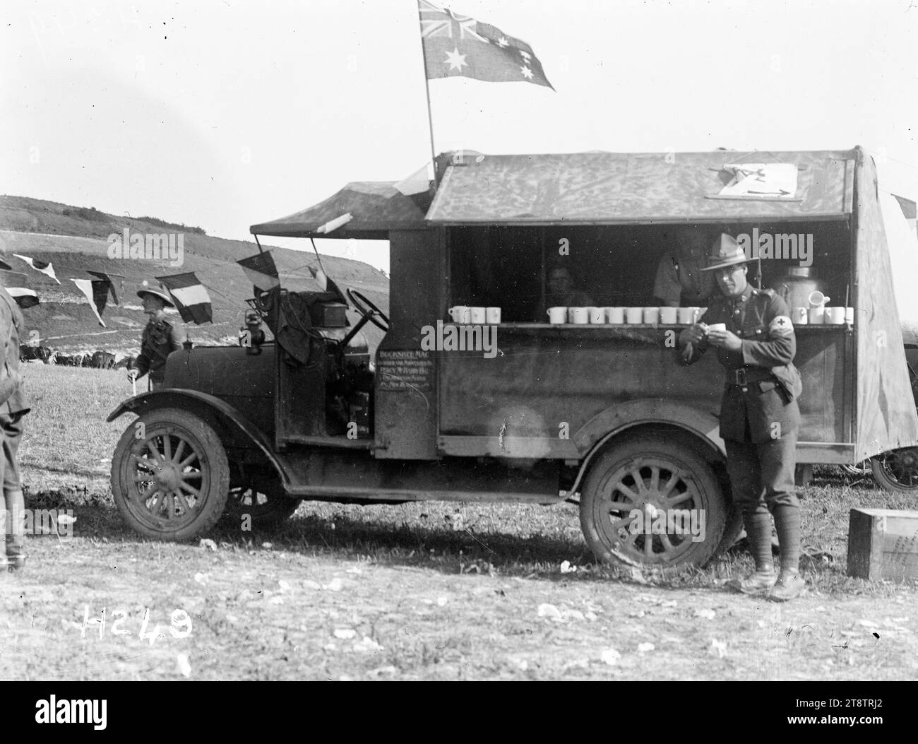 A mobile canteen at the Anzac Horse Show, World War I, A lorry nicknamed a 'Buckshee 'Mac' provides a canteen service to soldiers at the Anzac Horse Show during World War I. A row of mugs is visible on a shelf along one side of the vehicle. An Australian flag flies from its roof. Photograph taken France 16 September 1917 Stock Photo