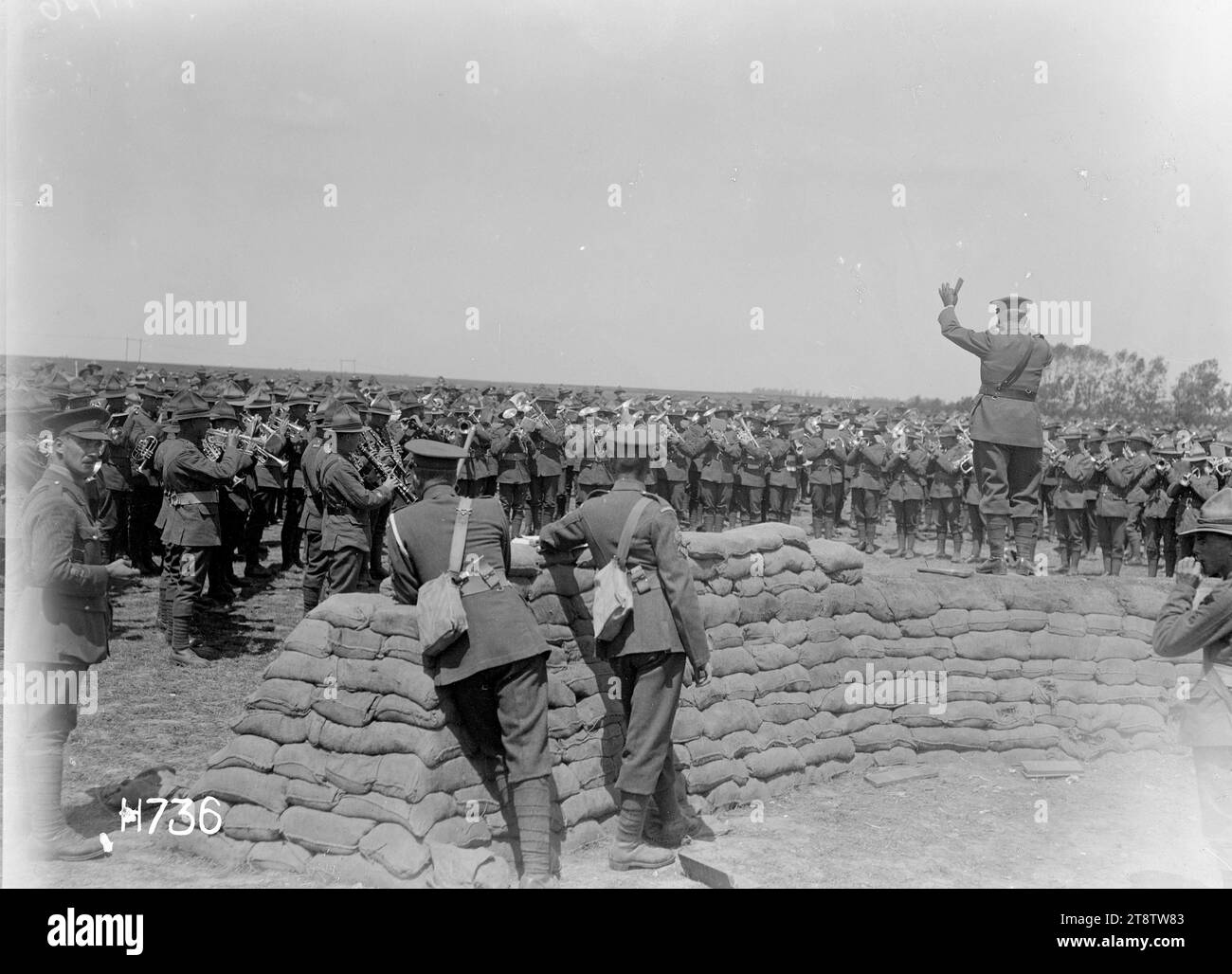 The massed bands being conducted at the New Zealand Divisional Band Contest, France, The massed military bands playing at the New Zealand Divisional Band Contest under the conductorship of the judge who stands on a wall of sandbags. Photograph taken Authie 27 July 1918 Stock Photo