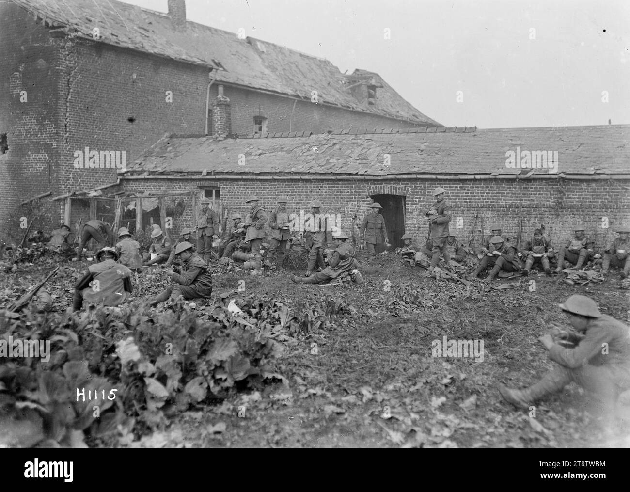 New Zealand soldiers eating after an attack near Solesmes, France, World War I, New Zealand soldiers sit eating lunch out of mess tins after an attack in France towards the end of World War I. They appear to be in a garden of a French dwelling near the town of Solesmes. Photograph taken 28 October 1918 Stock Photo