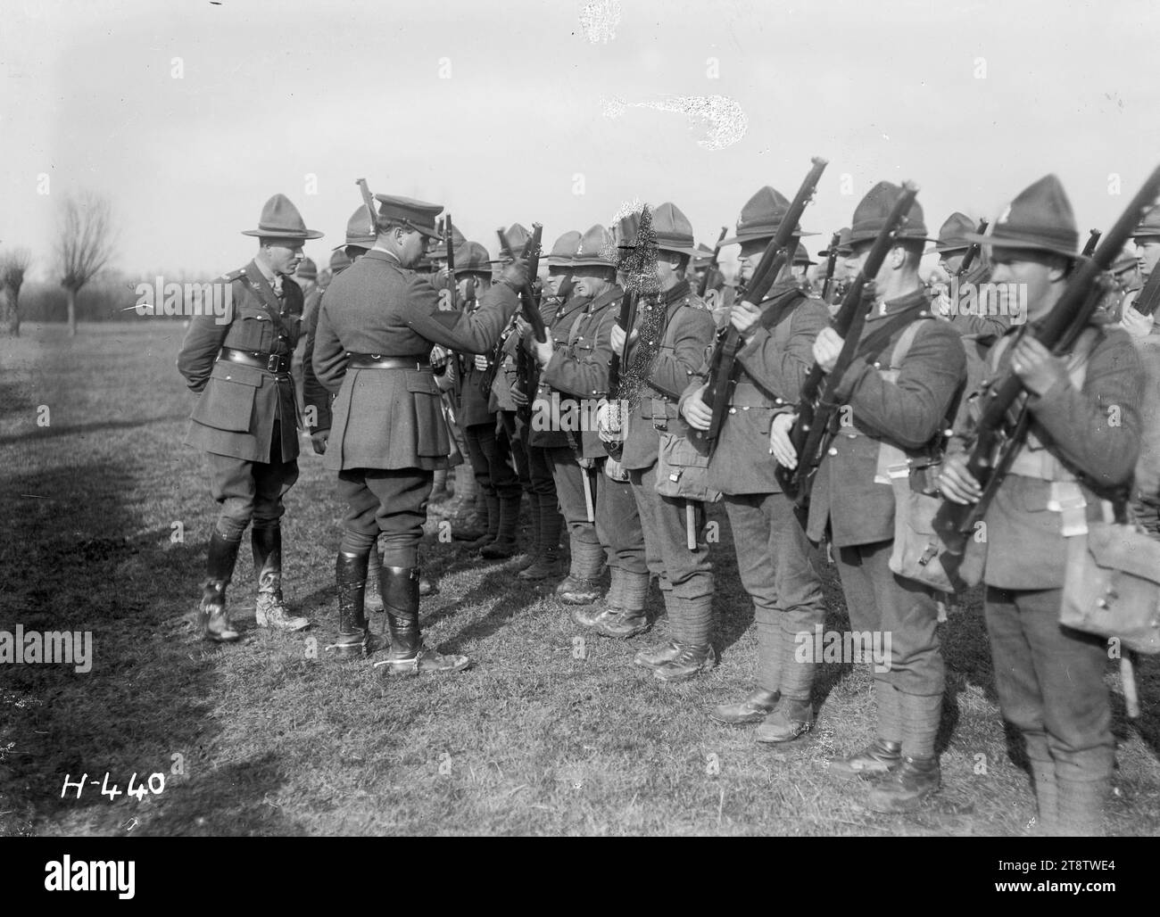 The GOC holds rifle inspection of an Otago battalion during World War I, The General Officer Commanding holds a rifle inspection of an Otago battalion stationed in France during World War I. He is standing in front of a row of soldiers and is examining the barrel of a rifle. Photograph taken 3 March 1918 Stock Photo