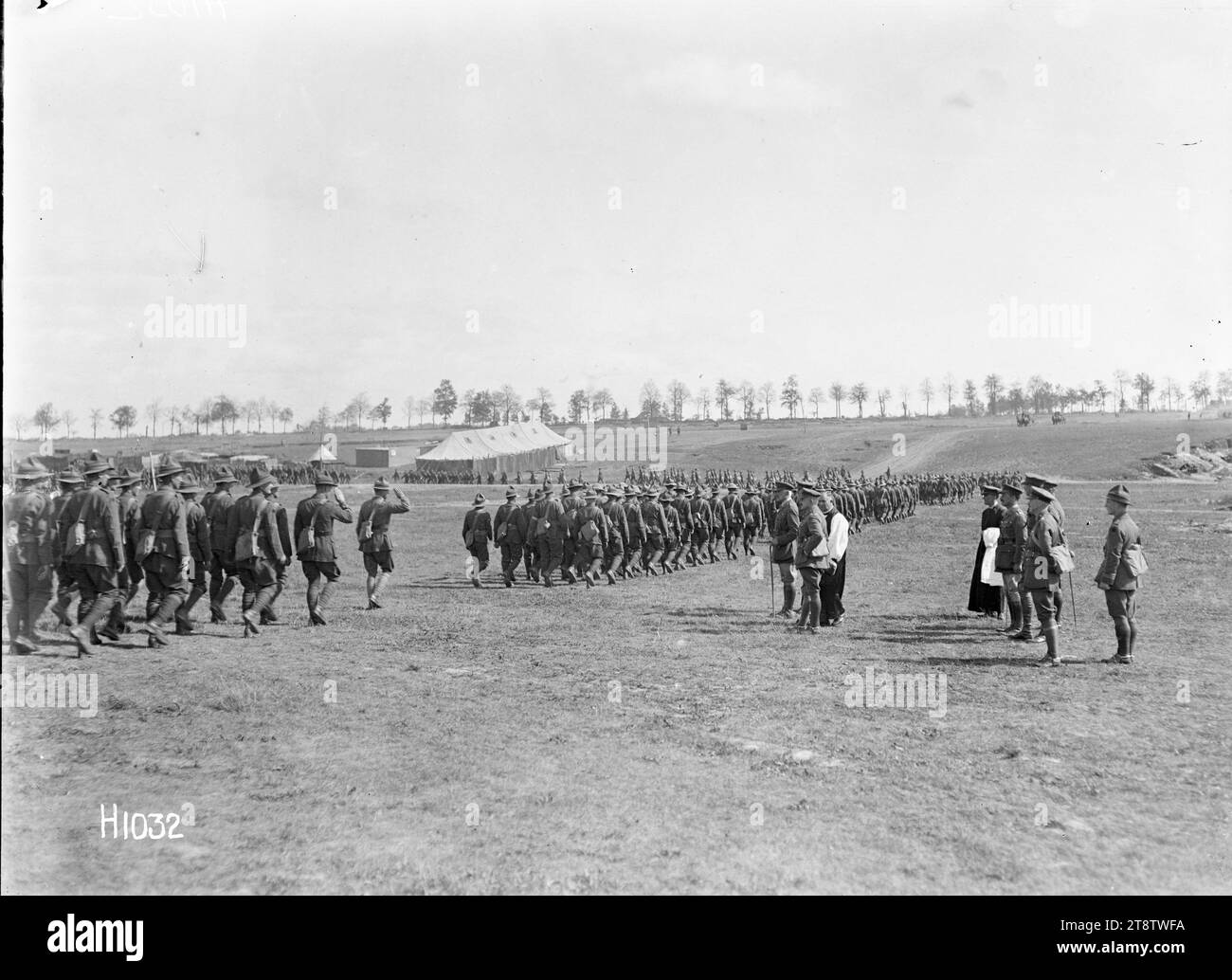 The salute after a New Zealand Brigade church service in France, World War I, A general view of the Corps Commander taking the salute after a New Zealand Brigade church service at Sapignies, France, during World War I. The Divisional Commanderl, General Russell, and the chaplain stand on his left. Other officers are behind them. Soldiers file past down a slight slope towards camp. Photograph taken 8 September 1918 Stock Photo