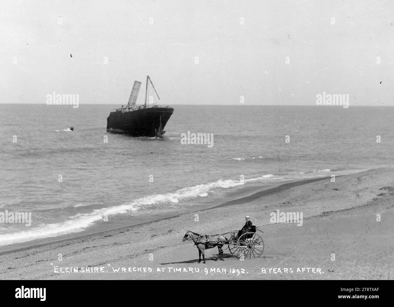 Timaru beach, showing the wreck of the ship Elginshire, and a man in a ...