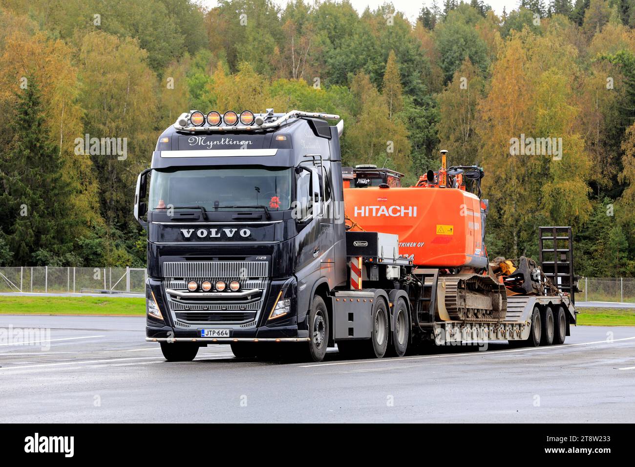 Volvo FH16 truck Mynttinen with low loader trailer carrying Hitachi Zaxis 225 excavator as wide load on a day autumn. Forssa, Finland. Sept 21, 2023. Stock Photo