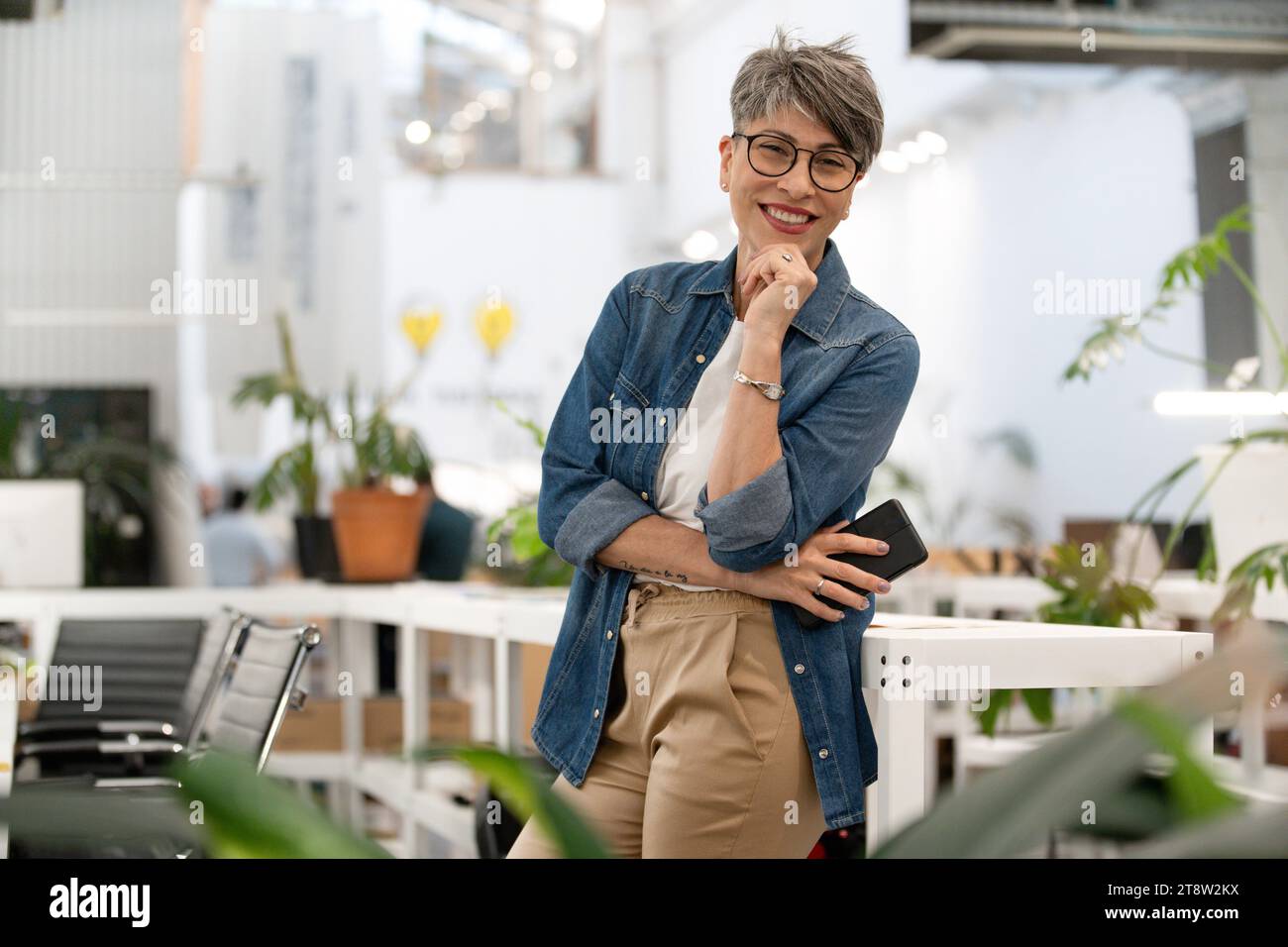 Female entrepreneur looking at the camera while standing indoors Stock Photo