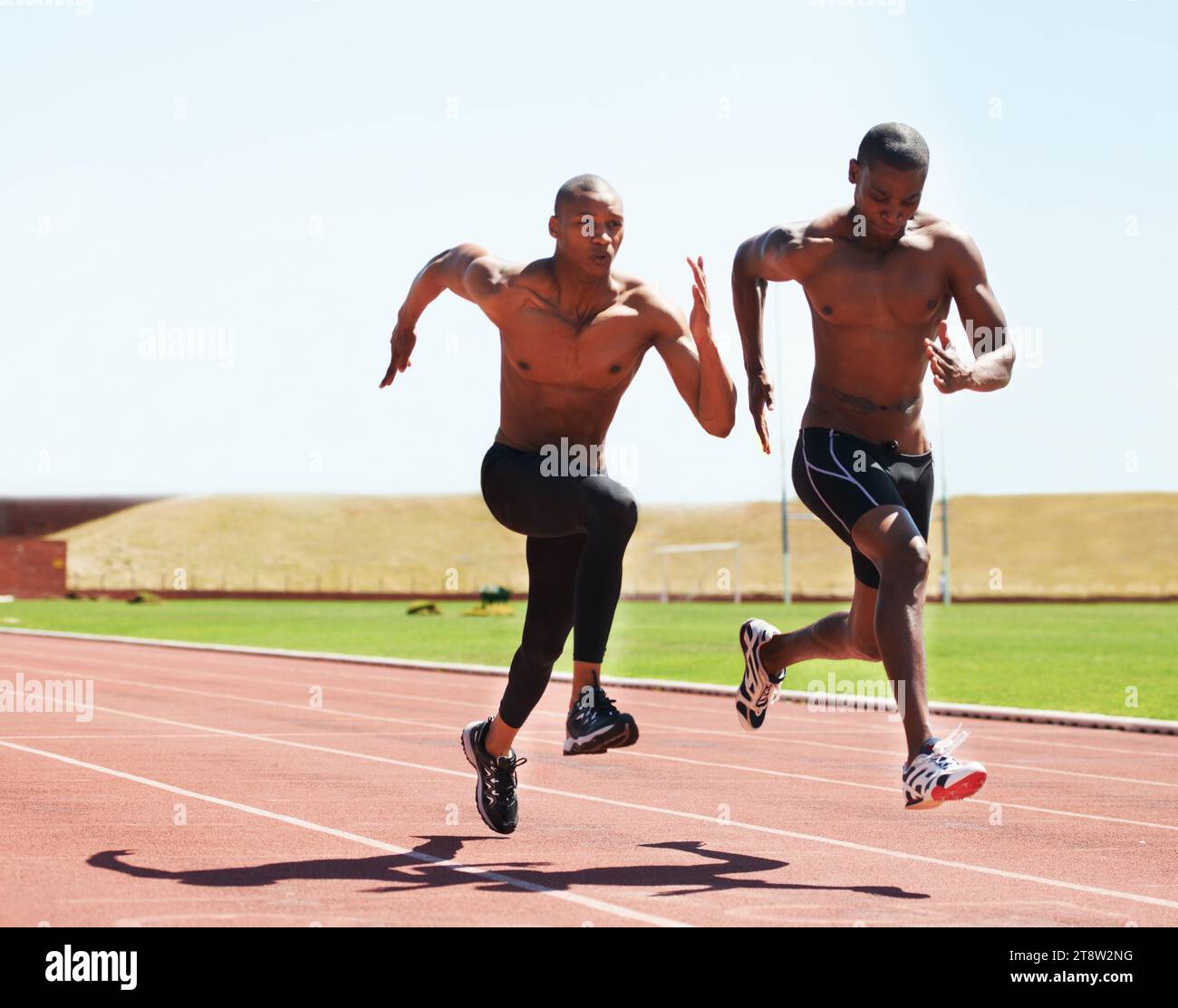 Man, athlete and running on track for race, practice or training for competition. Black people, together and competitive with dedication, motivation Stock Photo