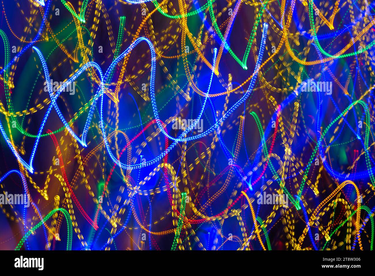 Blurred multi coloured light patterns streaks against a dark background creating abstract shapes Stock Photo