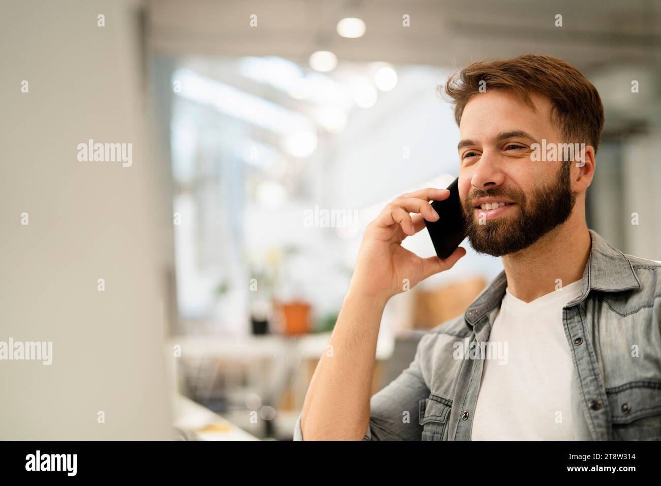 Male system engineer listening to voice mail while using computer Stock Photo
