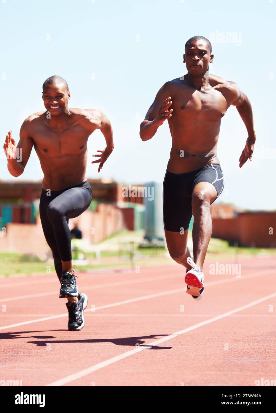 Man, athlete and running and competitive for race on track with practice for competition. Black people, together and passion for sport with dedication Stock Photo