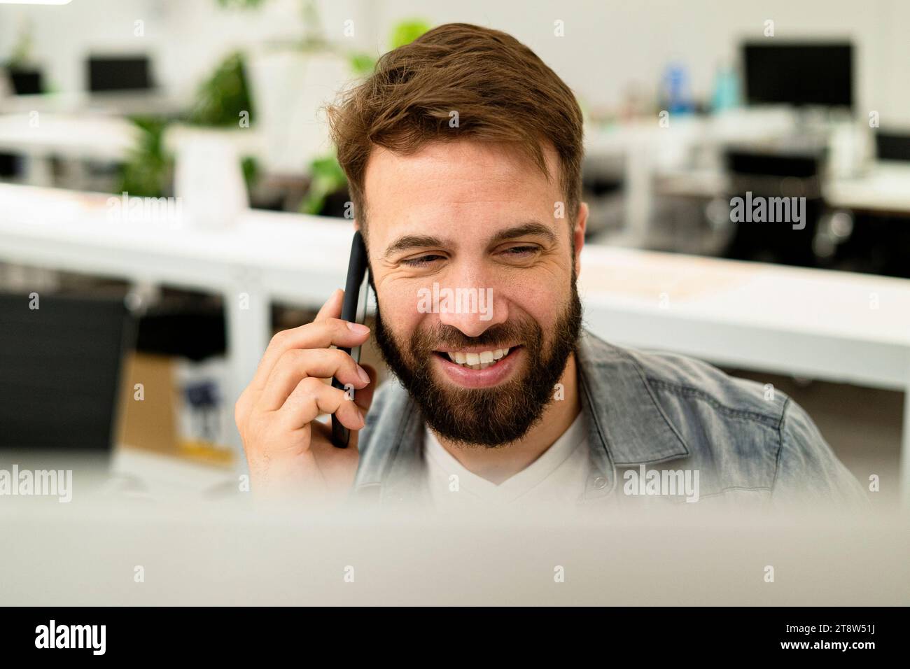 Male system engineer listening to voice mail while using computer Stock Photo