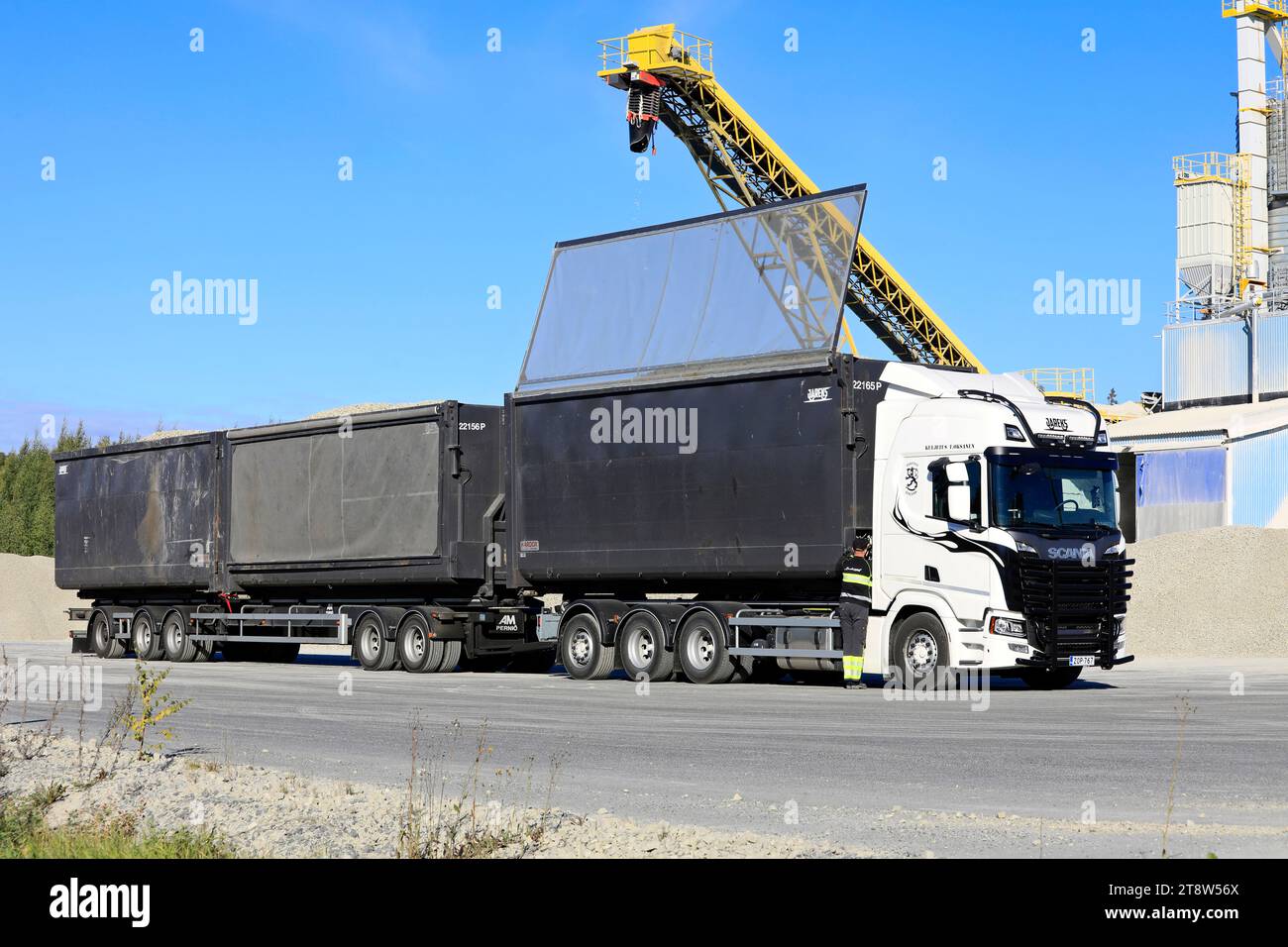 Scania 560R truck driver closes the trailer roof after loading foam glass aggregate at Uusioaines Oy production plant. Forssa, Finland. Sept 9, 2022. Stock Photo