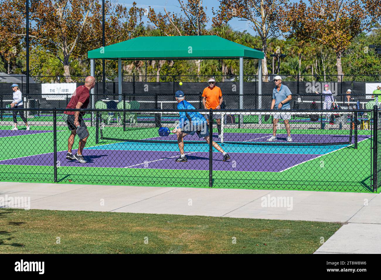 Active senior men's pickleball game at The Yards Pickle Garden in Ponte Vedra Beach, Florida