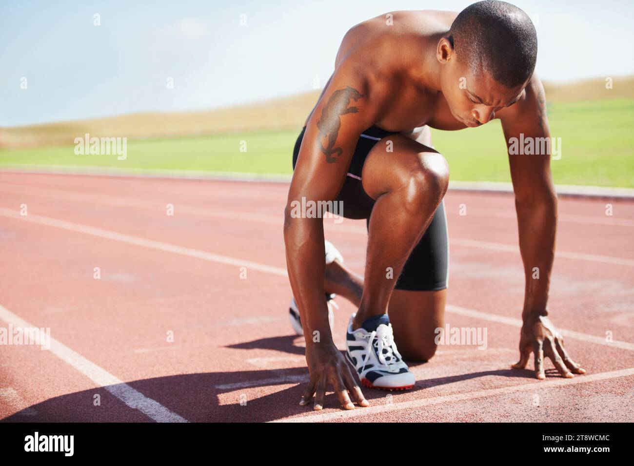 Man, athlete and ready for run on track with practice, training or workout for race. Black person, determination and concentration on face for go Stock Photo