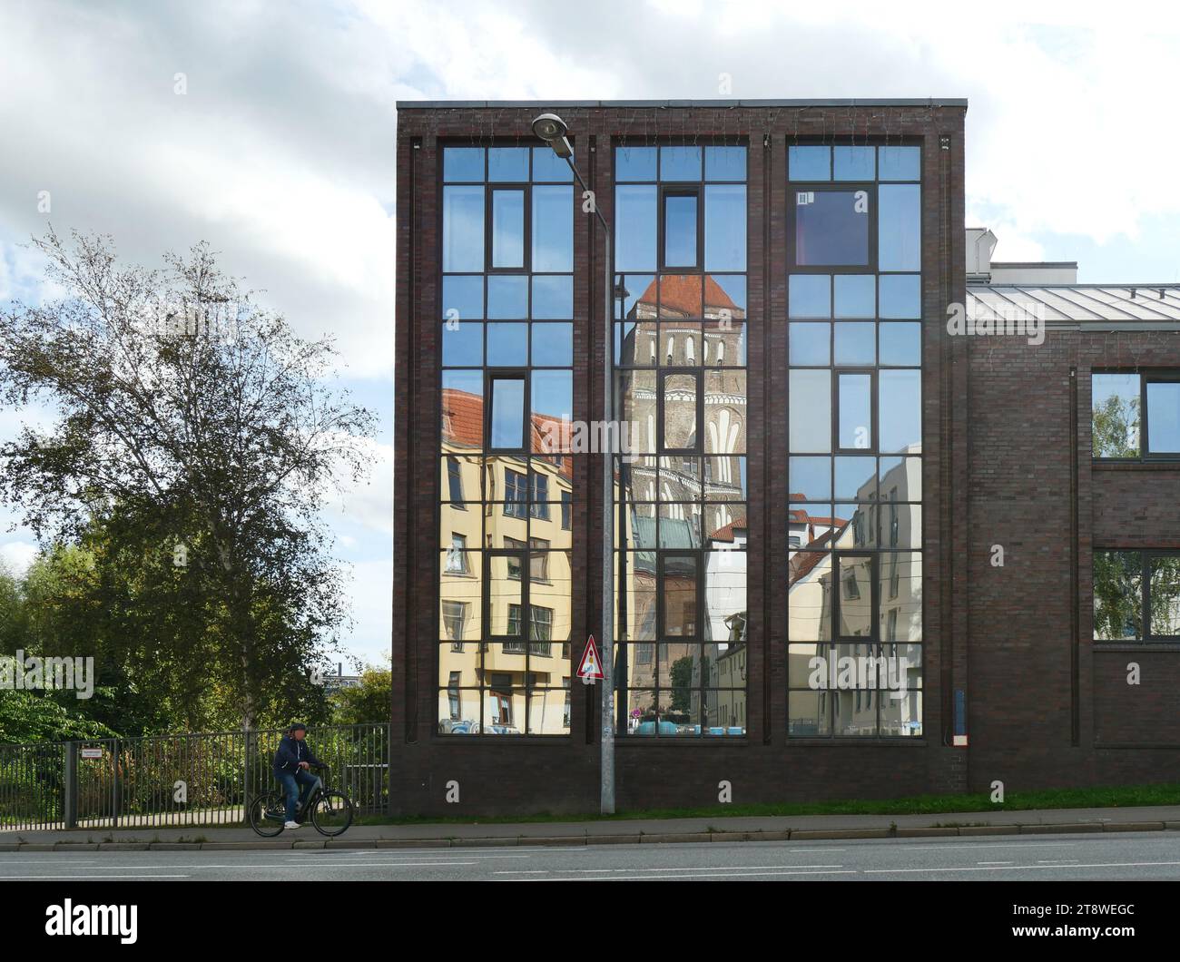 Glass facade of the building with reflection of St. Nicholas Church Stock Photo