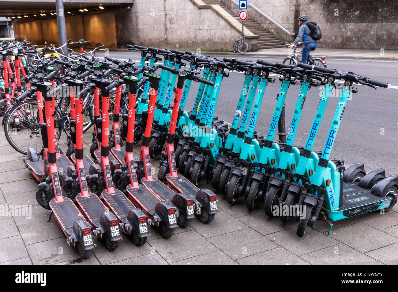 Tier and Voi electric scooters for rent are parked near the central station, Cologne, Germany. Tier und Voi Elektroscooter zum mieten stehen nahe Haup Stock Photo