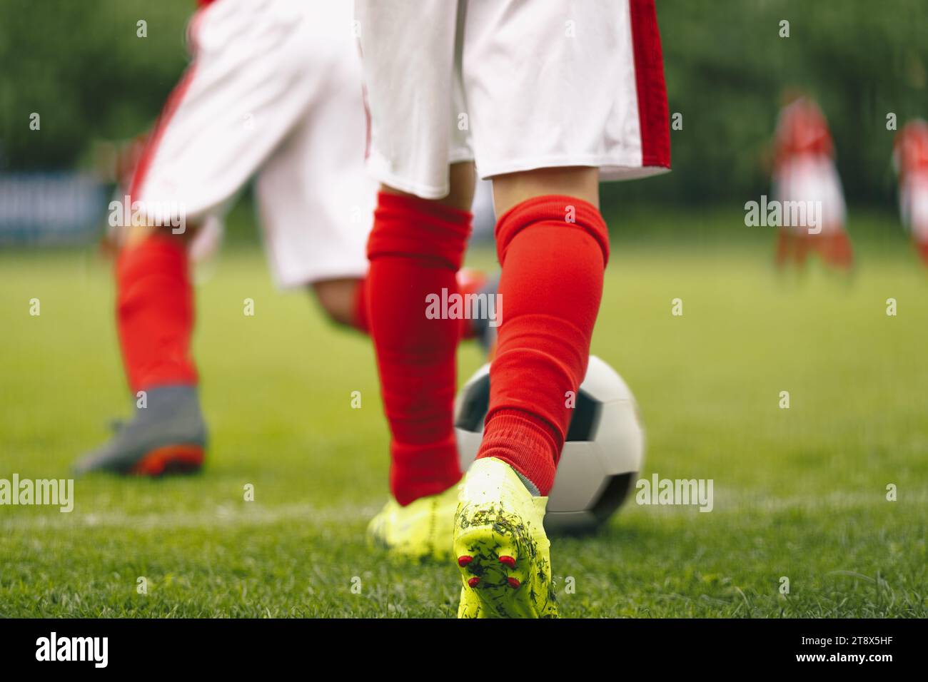 Boys attending soccer training on school field. Young multiracial football players at training camp. Soccer practice for children Stock Photo