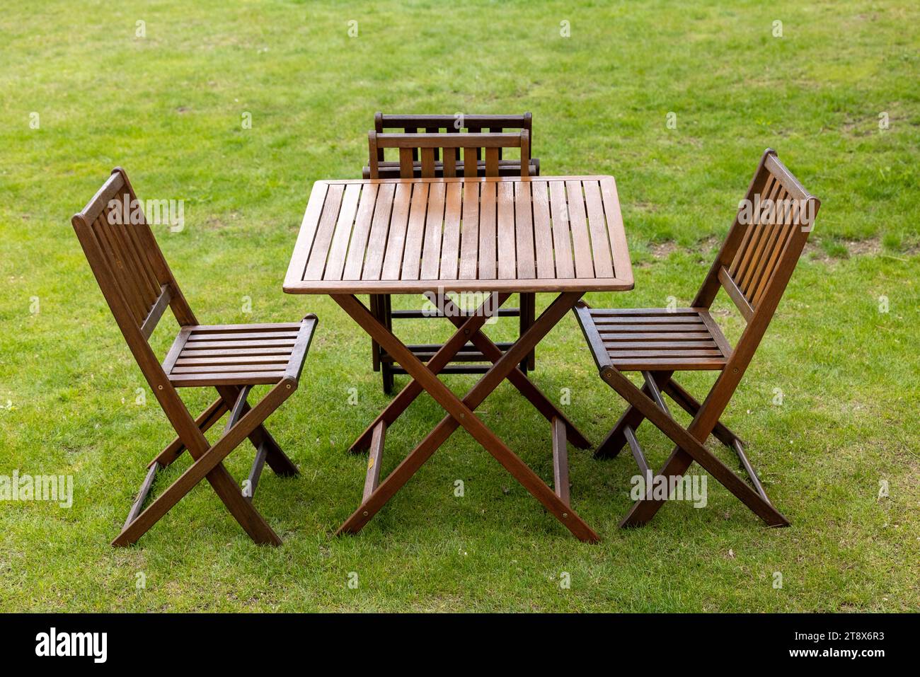 wooden table and chairs on the garden lawn Stock Photo - Alamy