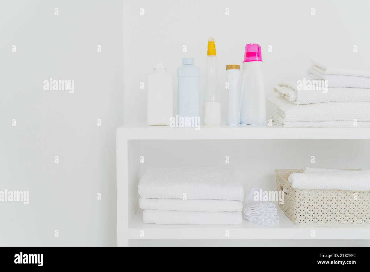 Neatly organized laundry shelf with clean towels and various detergents