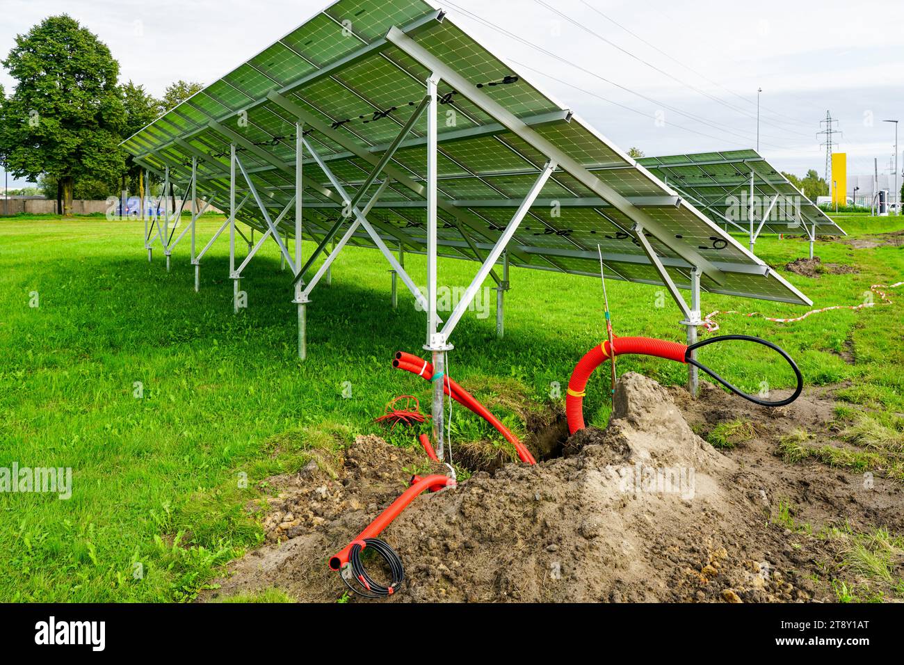 Installation of solar panels on metal frames in a green meadow ...