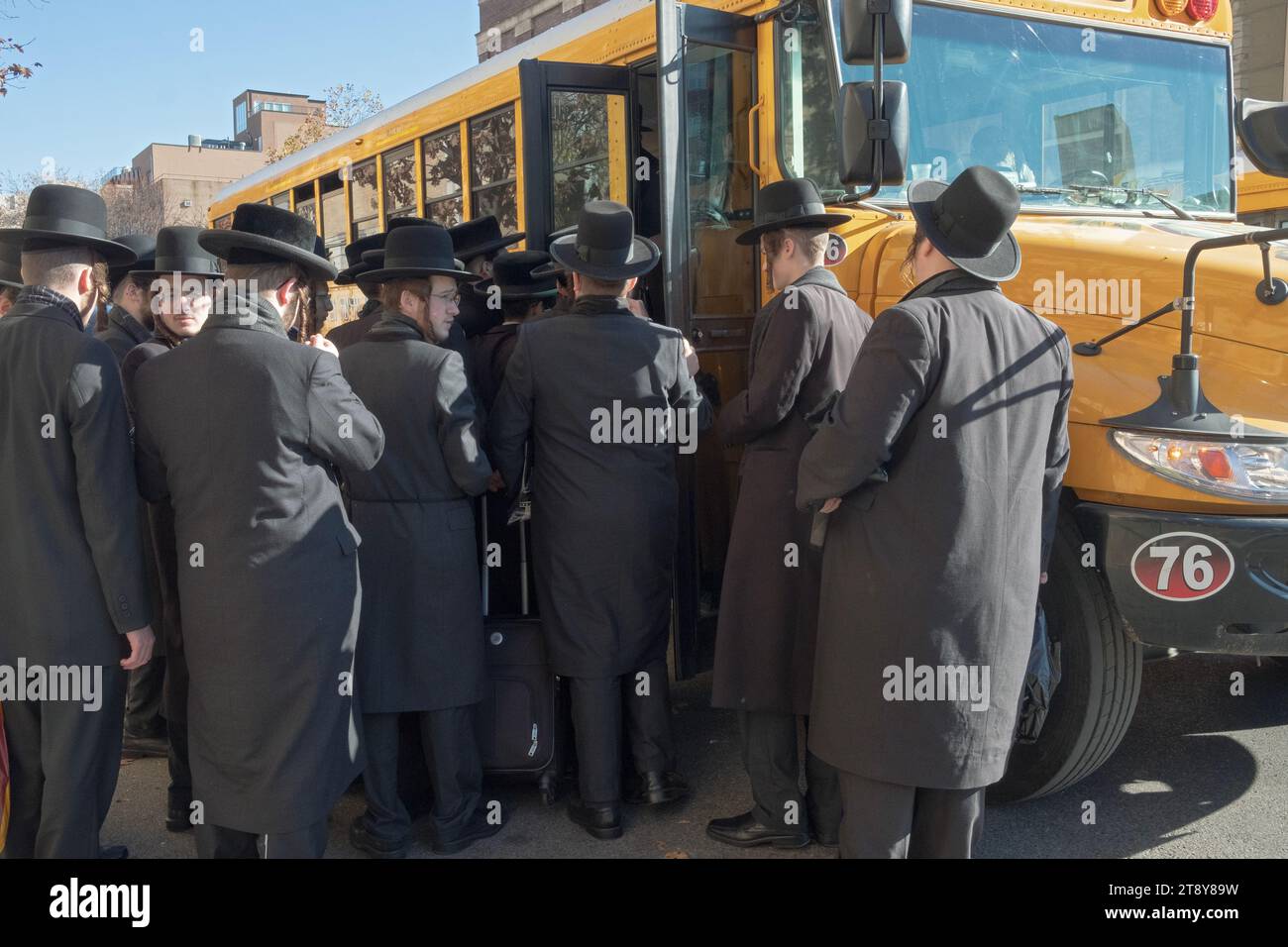 A large group of ultra orthodox Satmar Jewish men from Williamsburg  board a bus to go to a Talmud seminar day in another borough. November  19, 2023. Stock Photo