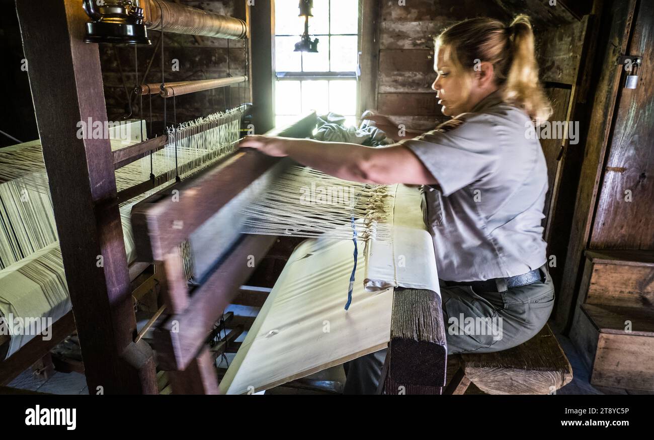 Park ranger demonstrates the use of a hand loom to make cloth, Mabry Mill, Blue Ridge Parkway, Virginia, USA Stock Photo