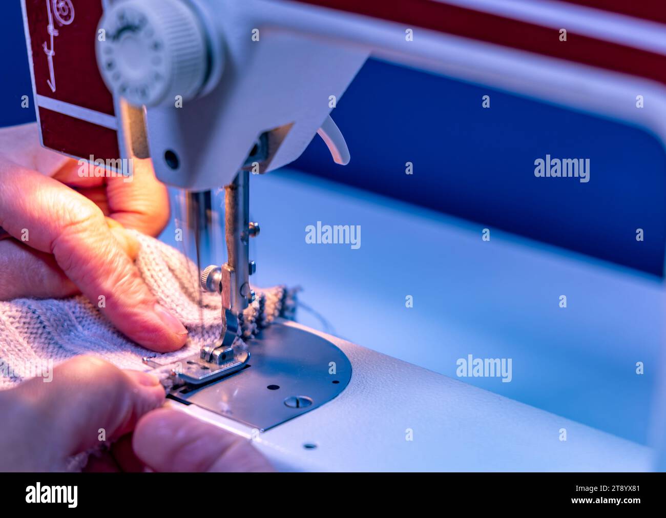 Sewing on a machine at home in a tailor's shop, repairing old clothes
