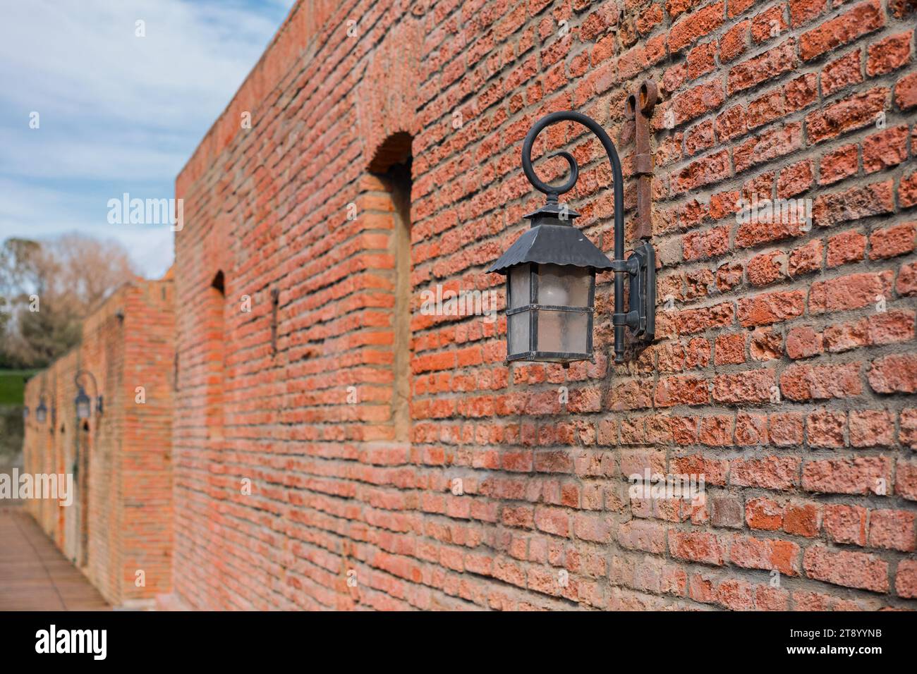Wall of red brick baths and street lamps in the old town in Tbilisi in
