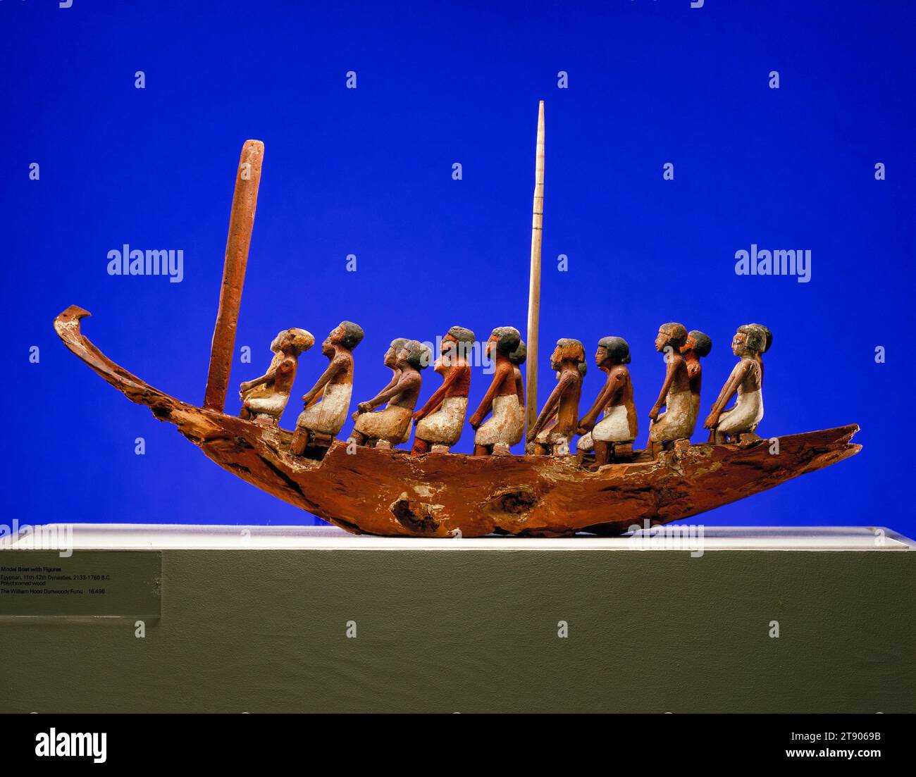 Model Boat and Figures, 22nd-18th century BCE, 27 x 37 1/2 x 6 in. (68.58 x 95.25 x 15.24 cm), Polychromed wood, Egypt, 22nd-18th century BCE, This boat, manned by eighteen oarsmen and equipped with a mast and a mount for the steering oar, is of the type commonly placed in the tomb of a deceased noble or government official. It faithfully represents the vessels used in daily life for fishing and for transportation on the Nile. A model boat enabled the deceased to make a pilgrimage by magical proxy to the city of Abydos, the cult center of the god Osiris. Sometimes two boats were provided Stock Photo